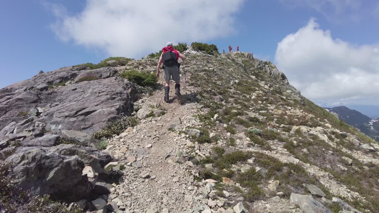 hombre alcanzando la cumbre del monte 5040, isla de vancouver, canadá