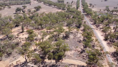 Drone-Cruzando-Una-Propiedad-De-Campo-Con-Una-Carretera-Y-Tanques-De-Agua