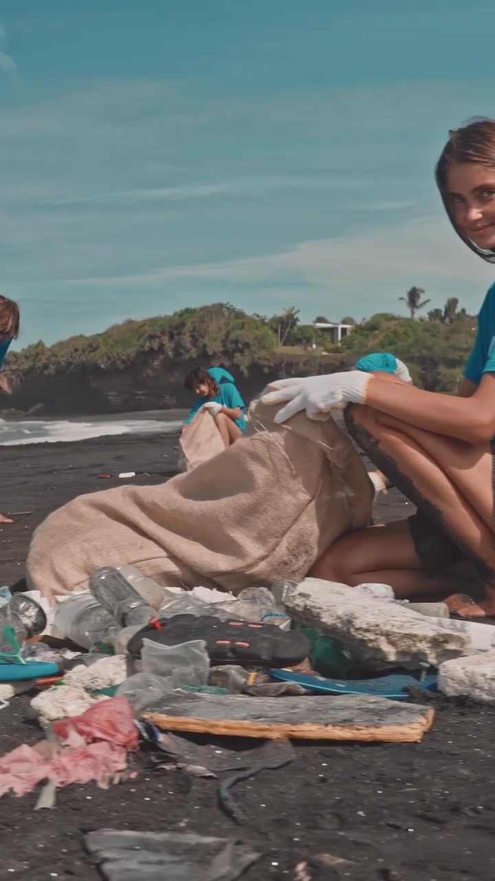 Volunteers clean trash from a beach during community service project