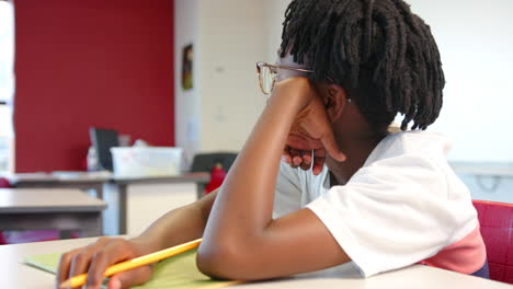 daydreaming in classroom, student holding pencil in school