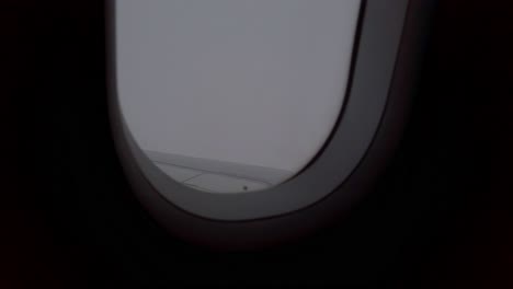 view of sky from inside airplane cabin while flying over cloud sky scape through the window with wing view in daytime