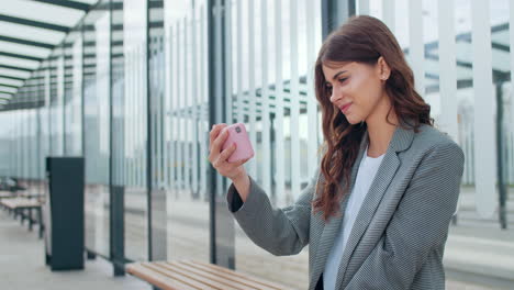 young woman using smartphone at modern bus stop