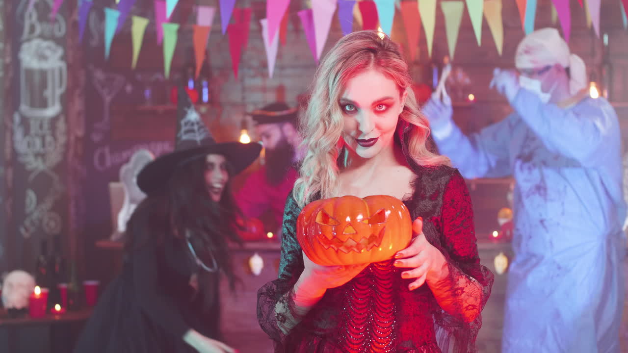 Halloween Party with Woman in Costume Holding Pumpkin