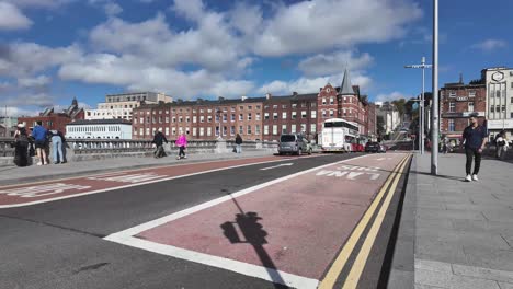 cork city st. patrick's bridge with road, traffic, bus and pedestrians on sunny day, ireland