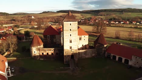 experience a breathtaking aerial view of a majestic castle nestled amidst a charming village