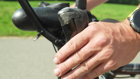 &quot;close-up of a hand resting on a bicycle handlebar