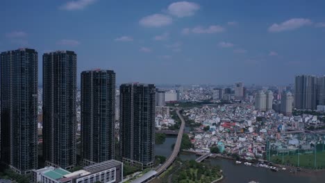 Ciudad-Ho-Chi-Minh,-Río-Saigón-Y-Horizonte-De-Binh-Thanh-En-Un-Día-Soleado-Y-Claro-Con-Edificios-Emblemáticos-Y-Del-Río-Dorado-Desde-La-órbita-De-Un-Dron