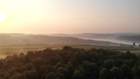 aerial view of a thicket and meadow with the sunset in the background