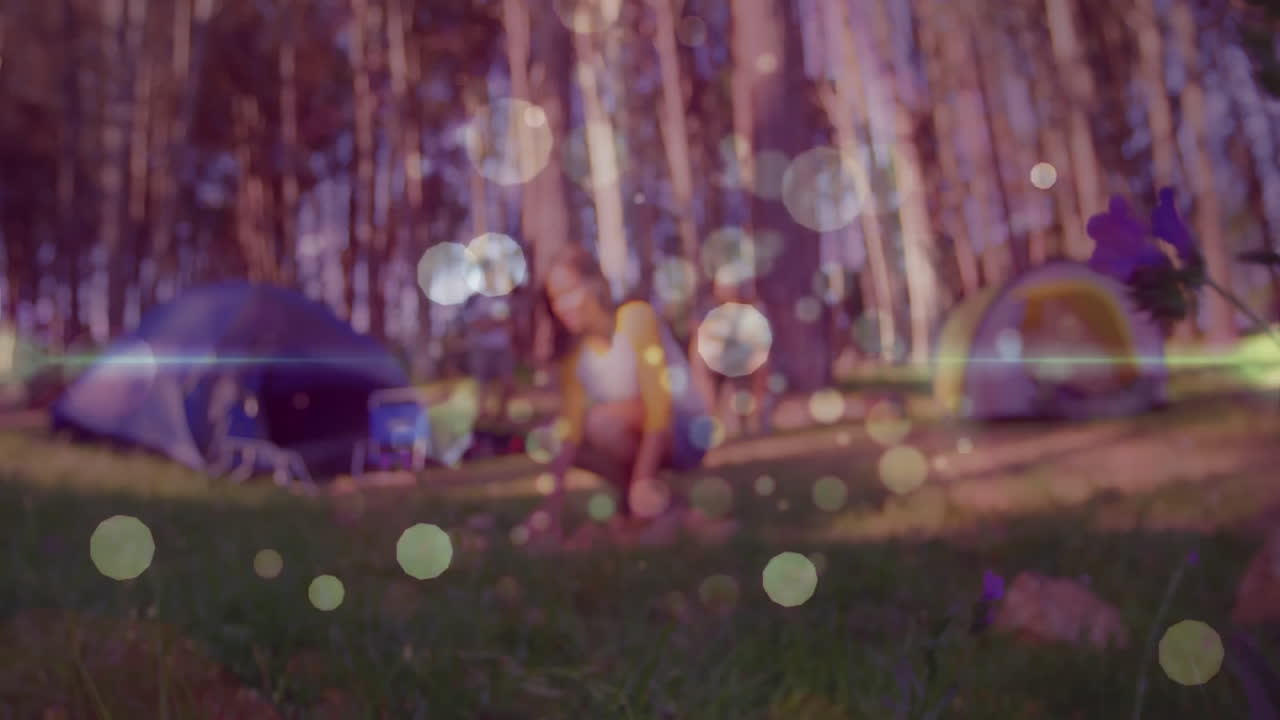Friends exploring technology via animated trail map and weather icons at forest campsite