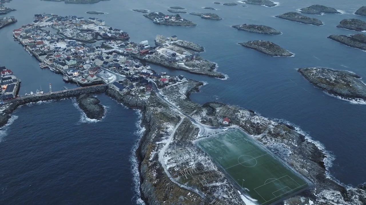 Norveç'in Nordland bölgesindeki Vagan'da yer alan Henningsvaer, Lofoten takımadalarındaki Austvagoya açıklarındaki adacıklar üzerinde, Vestfjorden'e bakmaktadır ve futbol stadyumu ile balıkçı köyü, bir drone'un yörüngesel hareketiyle aşağı doğru eğilerek çekilen genel bir planda gözler önüne seriliyor.