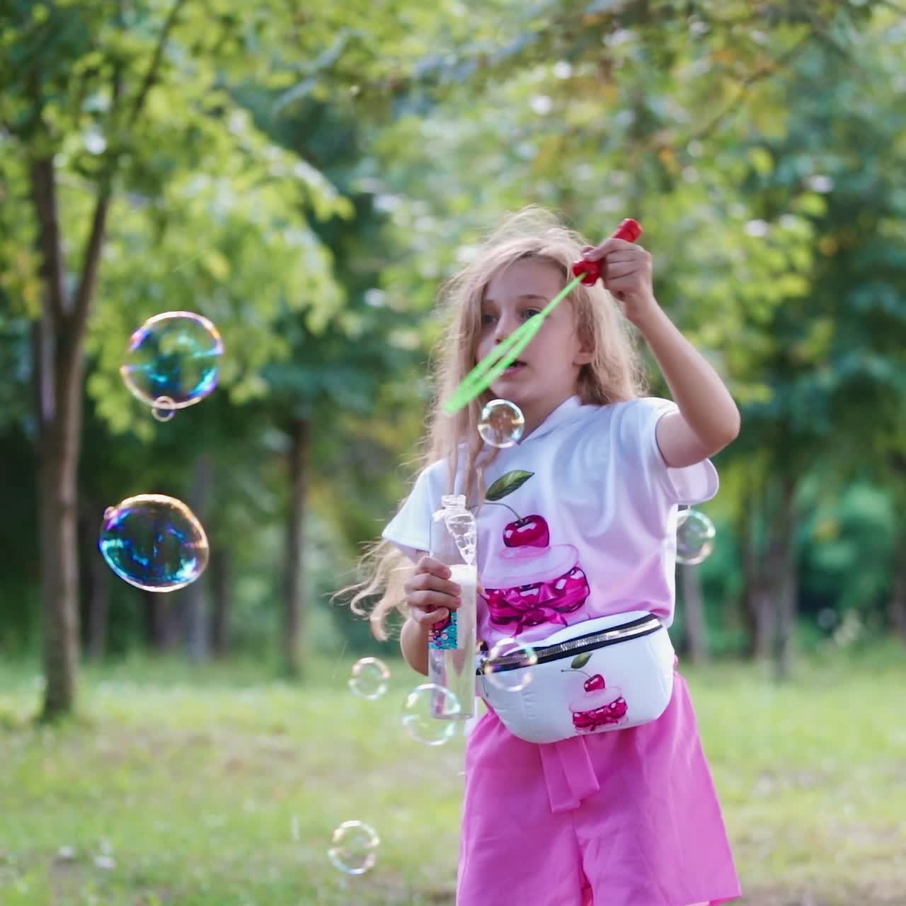 niña soplando pompas de jabón