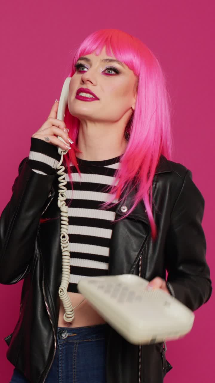 Video verticale: giovane alla moda che chatta al telefono su una linea telefonica vintage
