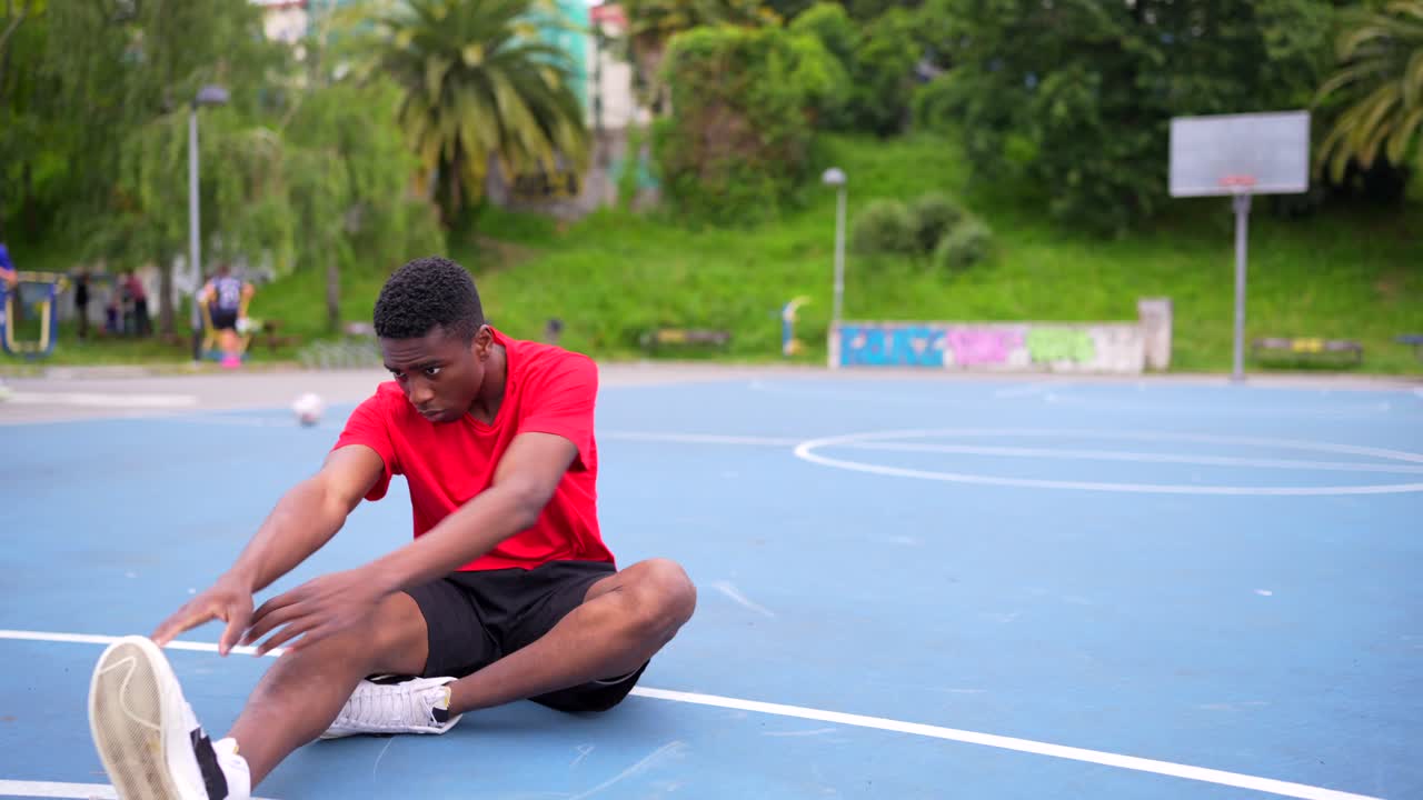 Uomo seduto su un campo da basket