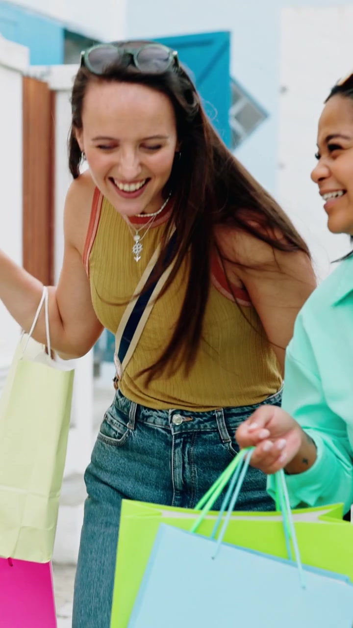 Due donne felici che camminano ridendo con le borse della spesa