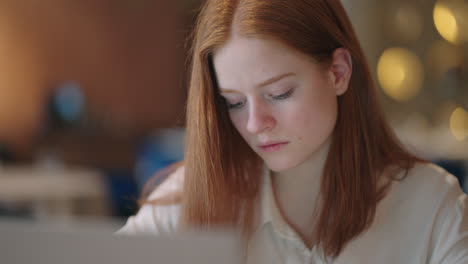 pretty student woman using laptop in outdoors cafe while having cup of coffee. cheerful woman working at cafe on laptop. businesswoman working during layover at modern airport.