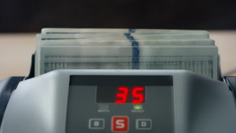 man putting dollars counter close up. machine calculating american banknotes.