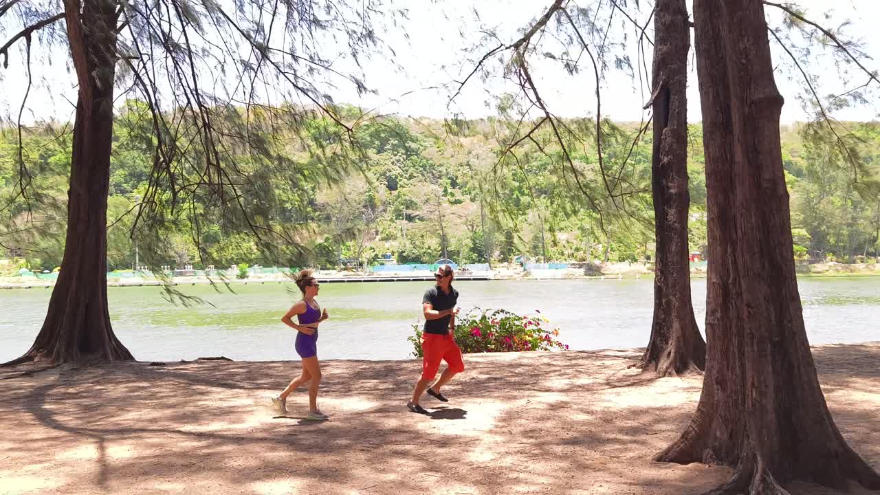 Couple Running in a Park by the Lake