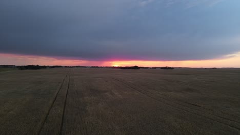 Ascending-wide-angle-drone-footage-of-vast,-expansive-farmland-in-the-prairies-of-Alberta,-Canada-at-sunset