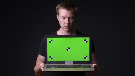 man holding laptop with chroma key green screen