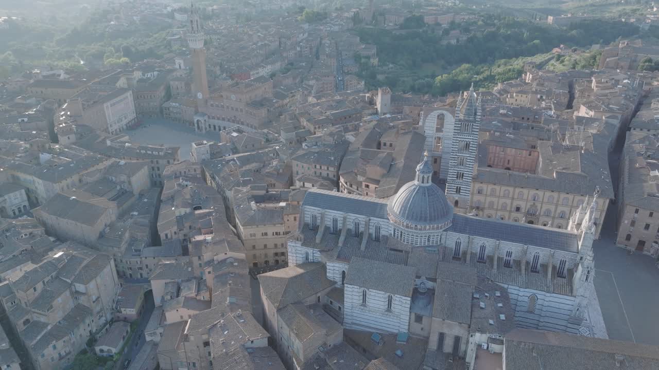 vista aérea de alto ángulo del duomo de siena, la piazza del campo y la torre del mangia en siena, toscana, italia al amanecer con la ciudad medieval en 4k, girando en el sentido de las agujas del reloj y panorámica hacia arriba