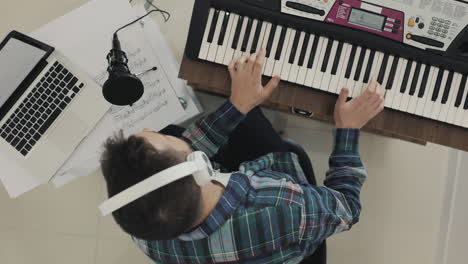 male musician singing and playing electric keyboard at home 2