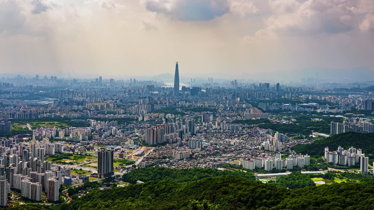 A wide-angle panning timelapse sweeps across the immense cityscape of Seoul, South Korea, revealing the sprawling urban landscape with the famous Lotte World Tower at its heart.