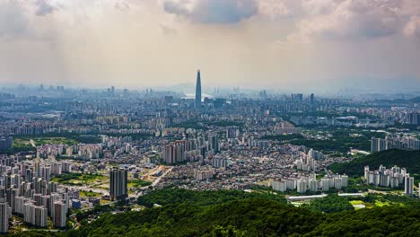 a wide-angle panning timelapse sweeps across the immense cityscape of seoul, south korea, revealing the sprawling urban landscape with the famous lotte world tower at its heart.