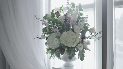 Wunderschöner-Blumenstrauß,-Aufgestellt-In-Einer-Modernen-Weißen-Vase-Mit-Einer-Wunderschönen-Weißen-Plattform-Und-Vorhängen-An-Einem-Nächsten-Veranstaltungsort-Und-Restaurant-Für-Hochzeitszeremonien-In-Stittsville,-Ontario
