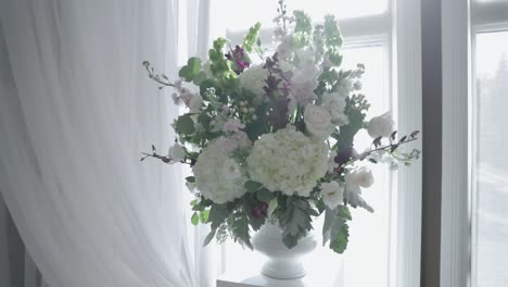 gorgeous flower bouquet set up in a modern white vase with a beautiful white platform and drapery at a next wedding ceremony venue and restaurant in stittsville, ontario