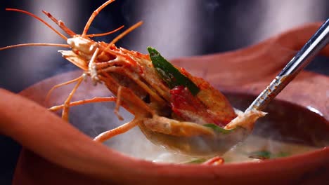 sopa de camarón caliente al vapor servida en una olla de arcilla tradicional, capturando la esencia de la cocina tailandesa, de cerca