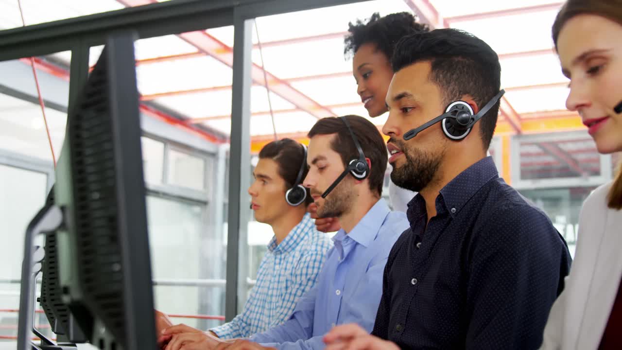 Business executives with headsets using computer