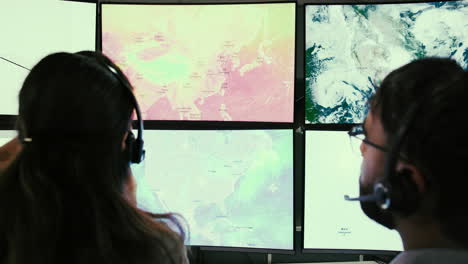 meteorologists analyze weather data on multiple screens