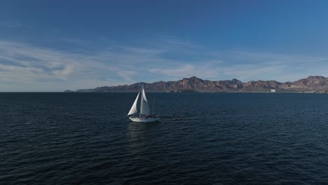 white-sailboat-sailing-in-the-sea-through-blue-water-with-bright-sun