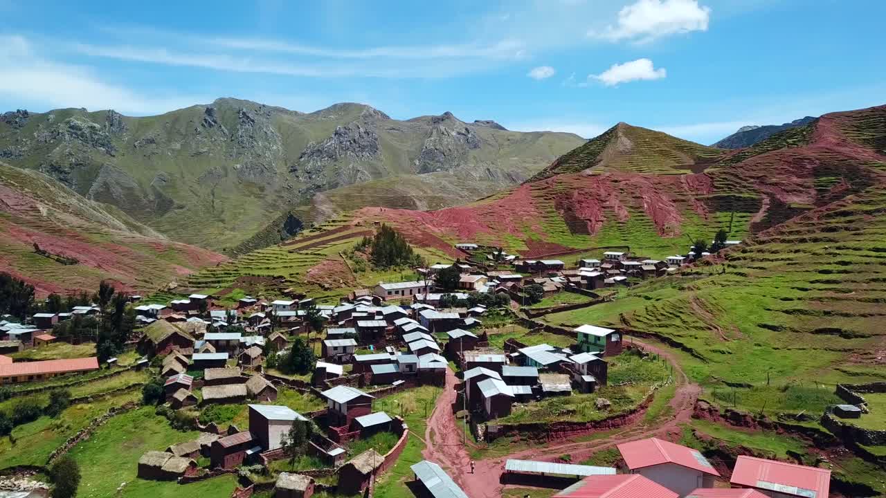 Ripresa aerea ascendente con drone sopra una piccola città, al centro di terrazzamenti e coltivazioni agricole, vicino a Palcoyo, in una giornata di sole, a Cusco, Perù, Sud America