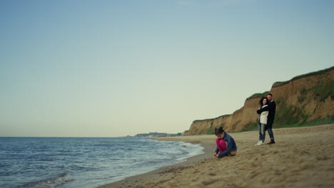 la familia descansa en la playa con las olas tranquilas. la gente disfruta de las vacaciones en el océano.