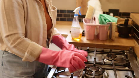 woman cleaning stove in kitchen