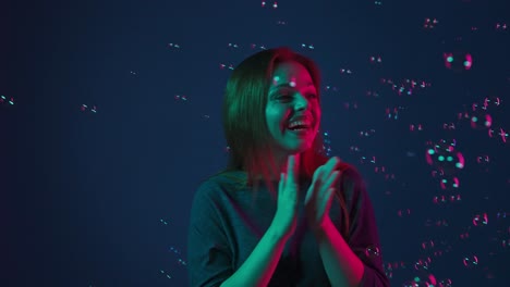 mujer jugando con burbujas a la luz de neón