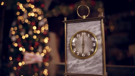 golden clock on blur christmas background. clock is showing six o'clock. the second hand moves in a circle of a mechanical clock. new year holiday. christmas concept.