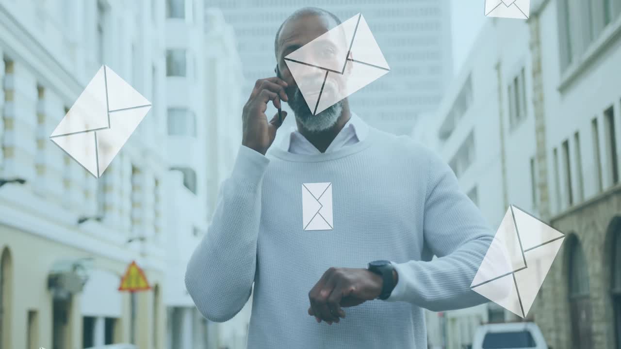 animación de iconos de sobres de correo digital sobre un hombre afroamericano que usa un teléfono inteligente en la ciudad
