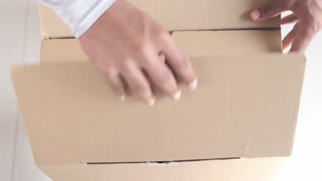 hands opening a cardboard box