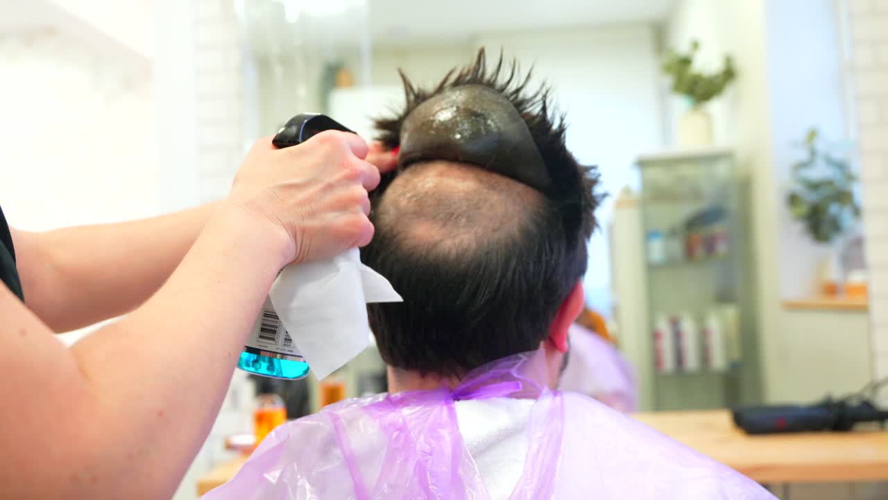 Hairdresser applying wig to client