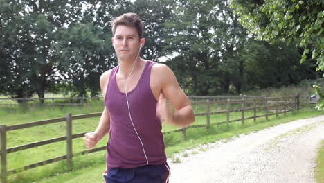 man running in countryside wearing earphones