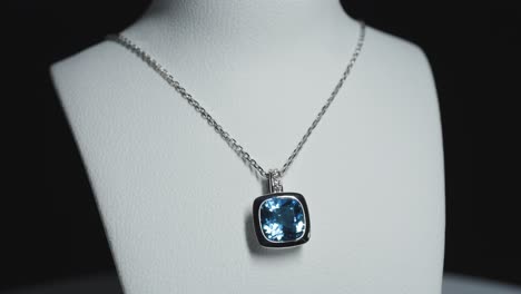 blue gemstone on a necklace on a rotating bust