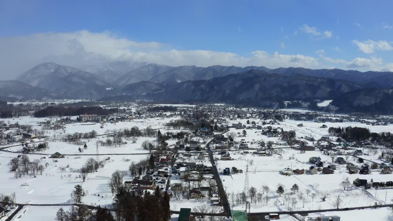 el avión no tripulado vuela con gracia sobre el impresionante valle de hakuba y la ciudad de hakuba en japón, capturando la belleza del paisaje invernal bañado en el cálido resplandor de un día soleado