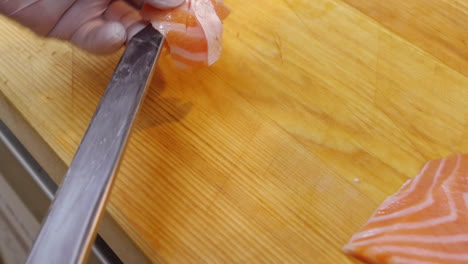 a chef slices a salmon fillet. raw seafood