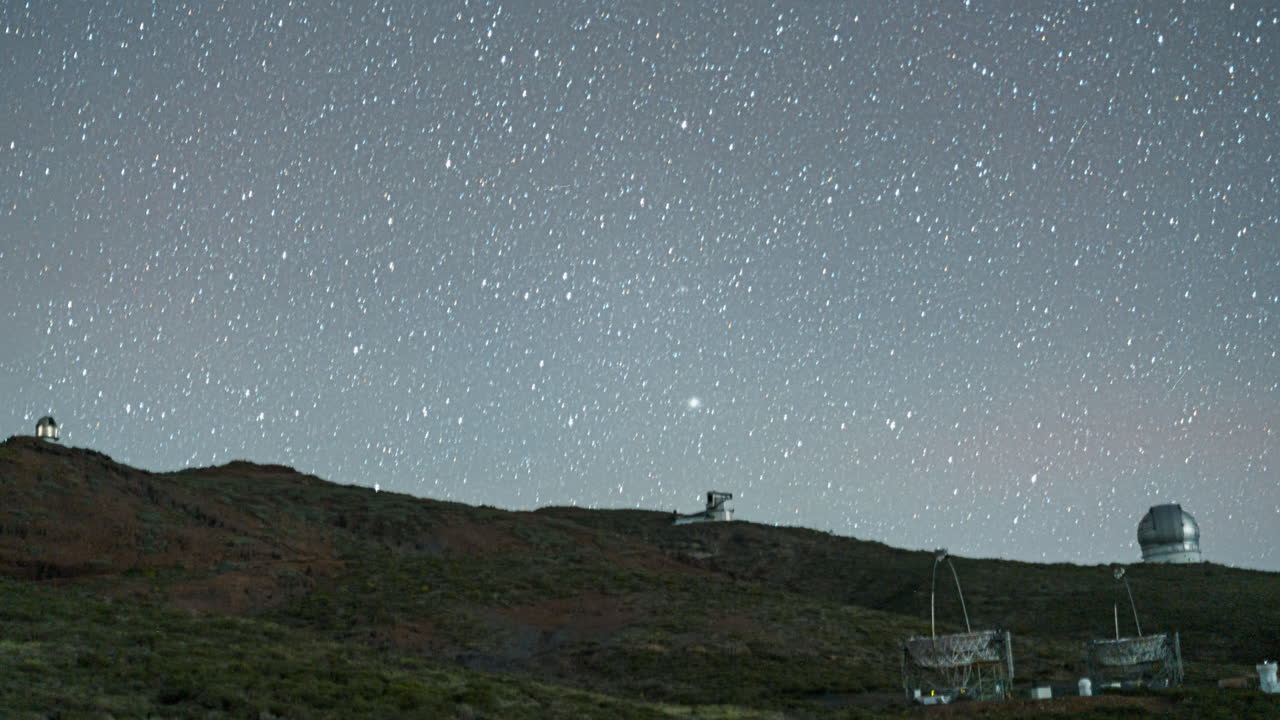 Roque de los Muchachos Observatory on the rugged mountain landscape under a clear sky into the night, timelapse