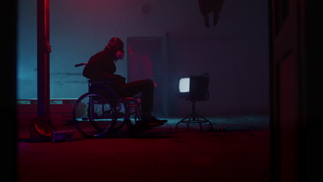 person in wheelchair in abandoned building at night