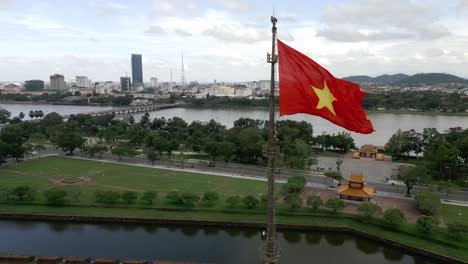 360 aerial shot around the vietnamese flag in hué, vietnam on a beautiful day in lush greenery