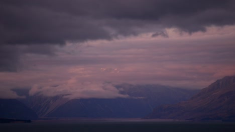 mount cook partially covered by colourful evening clouds