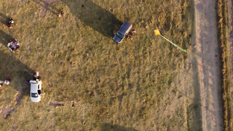 aerial top down shot of colorful kite flying at sky during windy day at sunset